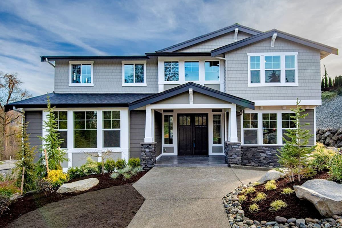 House plan exterior. Two-story home with a gabled roof, stone accents, and a covered front porch supported by columns.