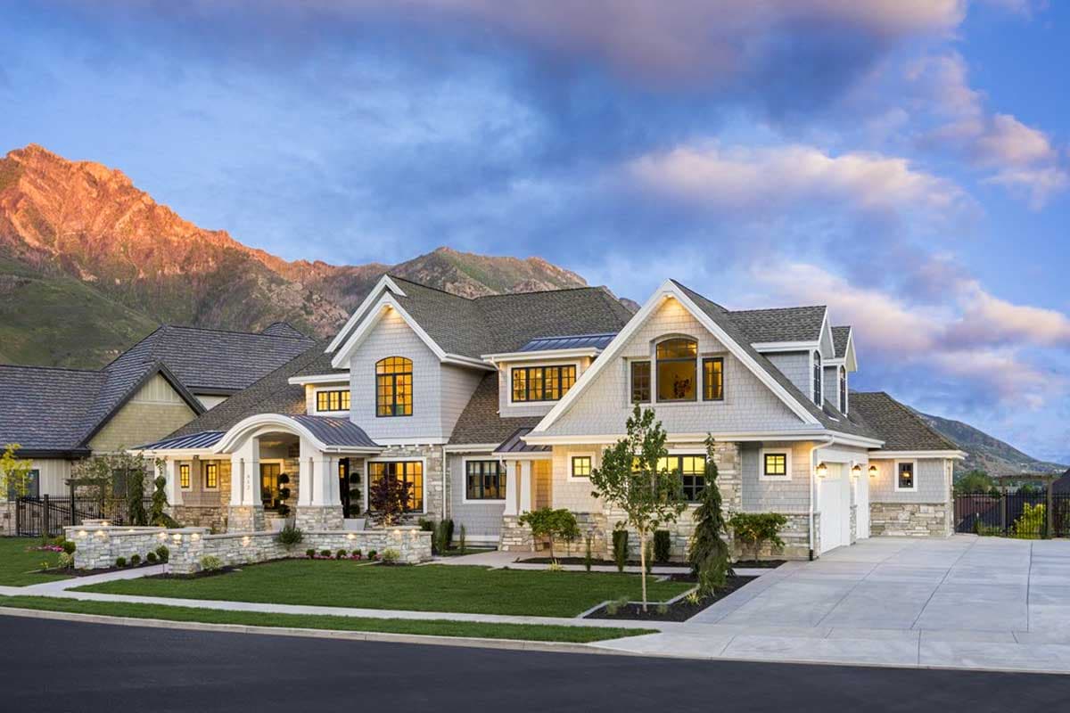 House plan exterior with Craftsman influences. Features include gables, stone accents, and a covered entry. Two-story structure with attached garage.