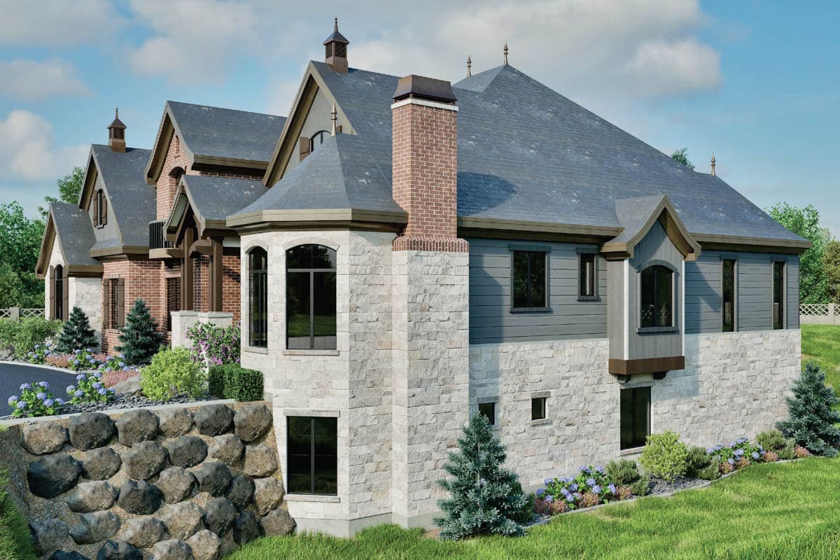 House plan exterior rendering of a multi-story home with stone and brick facade, multiple gables, dormers, and a prominent brick chimney.