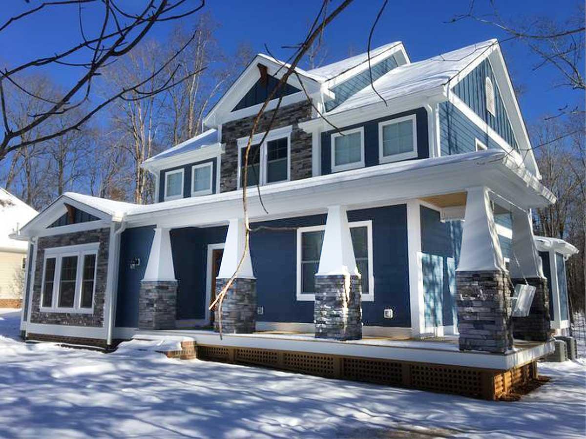 House plan exterior with two stories, Craftsman style. Features include a covered porch with stone columns, multiple gables, and a prominent roofline.