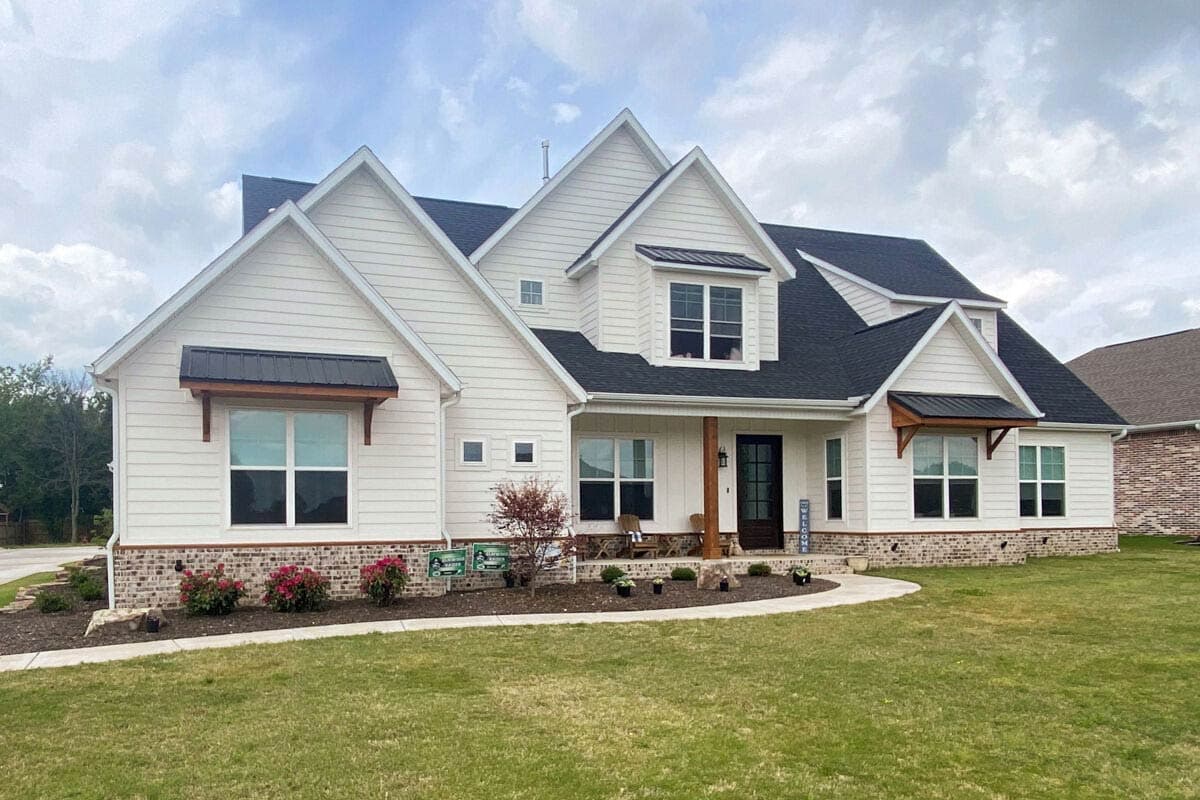 Modern Farmhouse style house plan exterior with white siding, gables, dormers, and a covered front porch.
