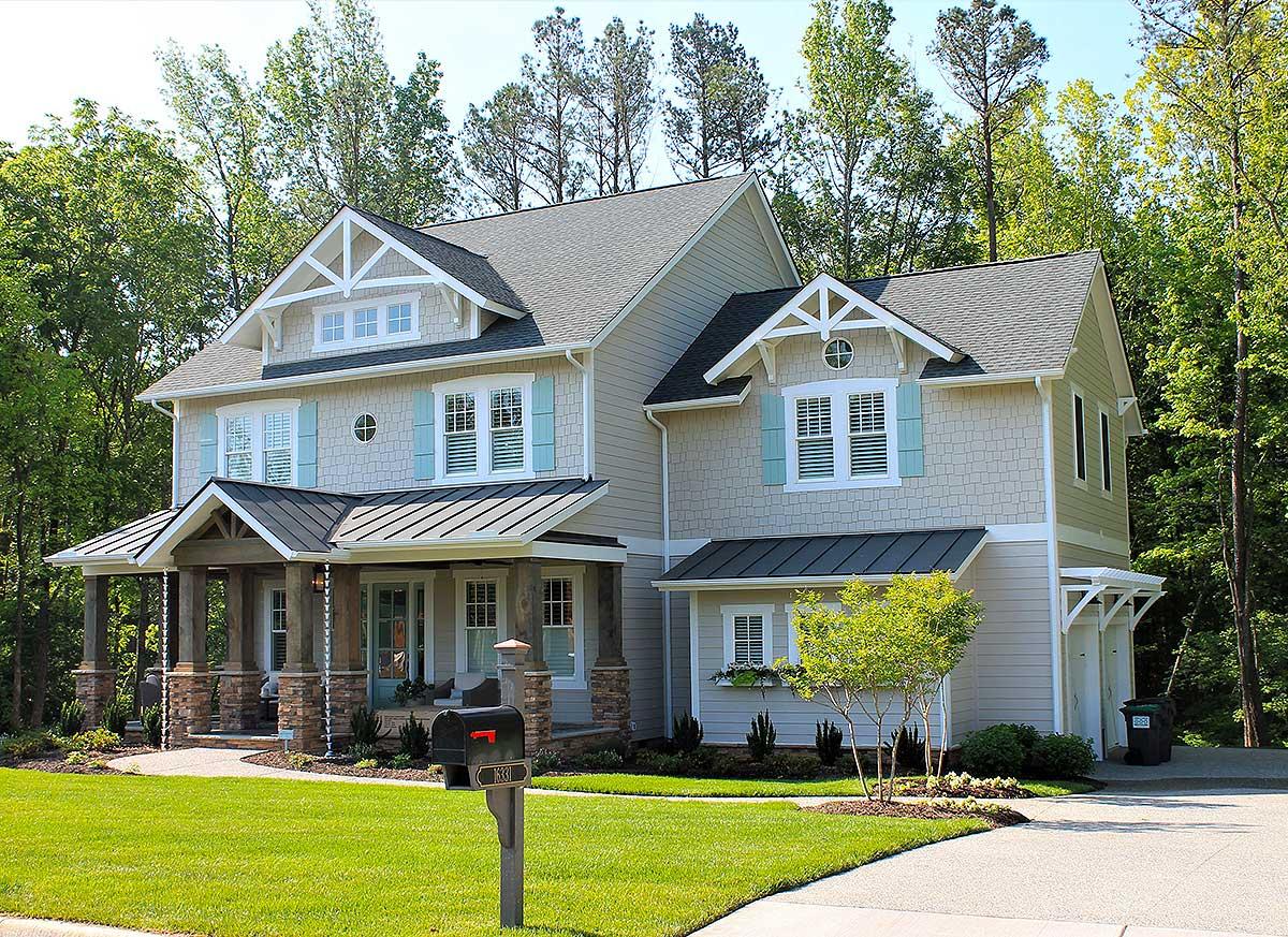 House plan exterior of a two-story Modern Farmhouse with gabled dormers, a covered porch, and a metal roof.