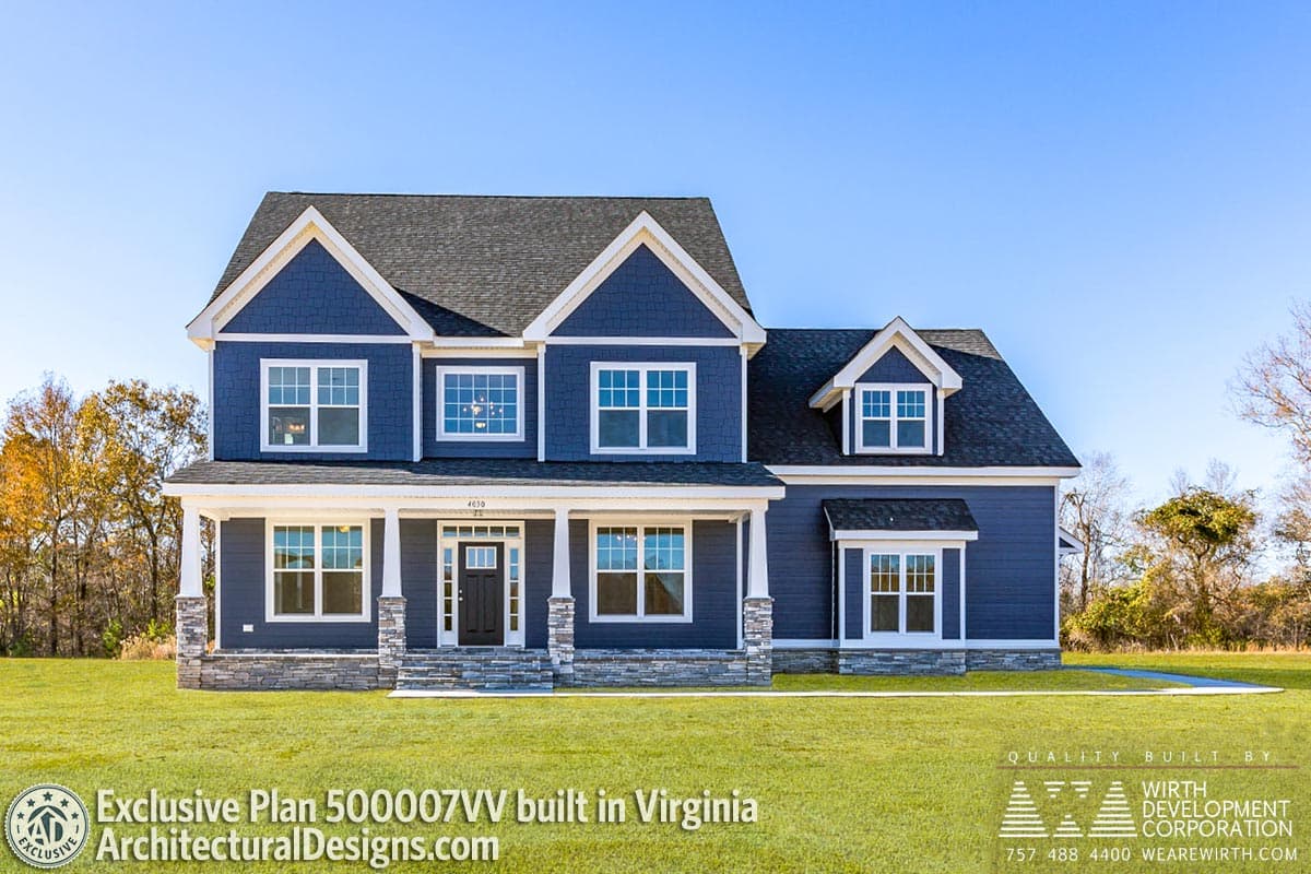 House plan exterior: Blue two-story home with gables, dormers, covered porch with stone pillars, and stone foundation.