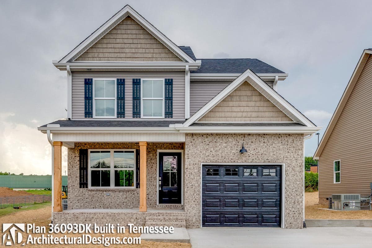 House plan exterior: Two-story home with brick base, covered front porch with wood columns, gable accents, and attached garage.