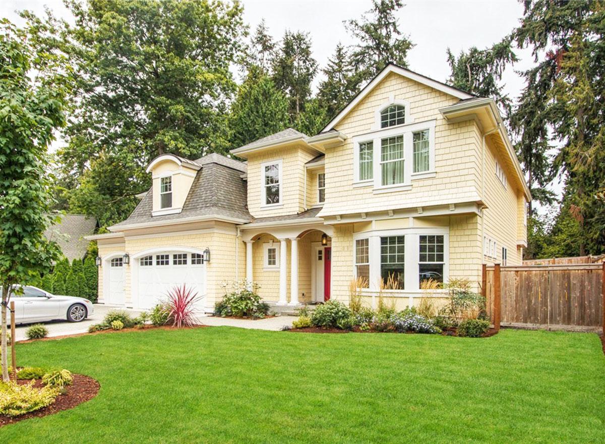House plan exterior with Craftsman style, two stories, front porch, dormers, and a gabled roofline. Attached garage on the left.