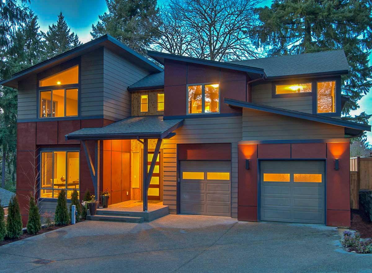 Modern two-story house plan exterior with asymmetrical rooflines, large windows, covered entry, and two-car garage.