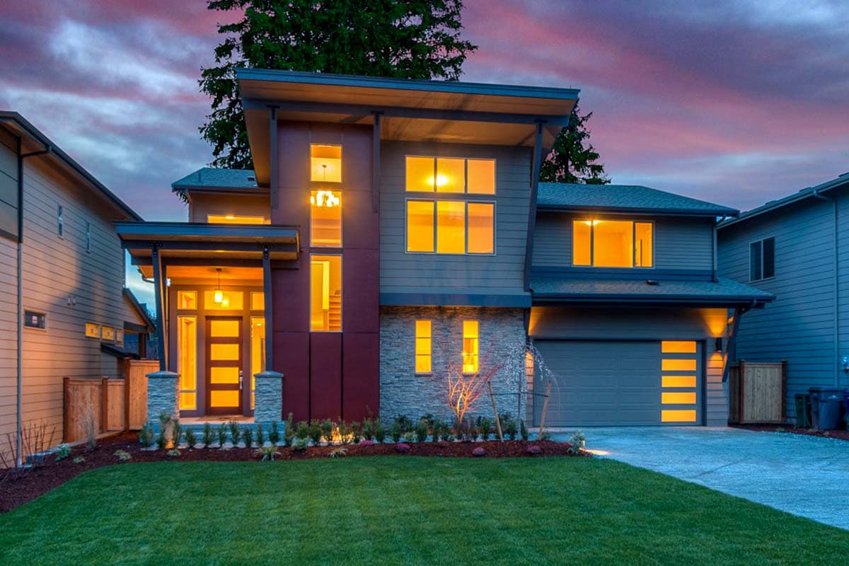 Modern two-story house plan exterior with asymmetric rooflines, stone accents, prominent entry, and garage.