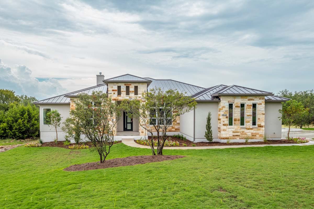 House plan exterior with metal roof, stone accents, and prominent gables.