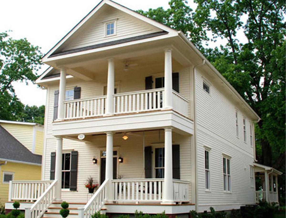 Two-story house plan exterior featuring a front porch with columns, a second-story balcony, and a gabled roofline. White siding and dark shutters.