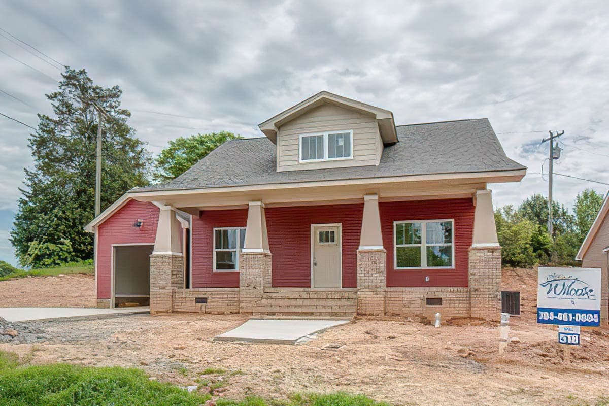House plan exterior. Craftsman style, one story home with front porch and dormer. Features include columned supports and attached garage.