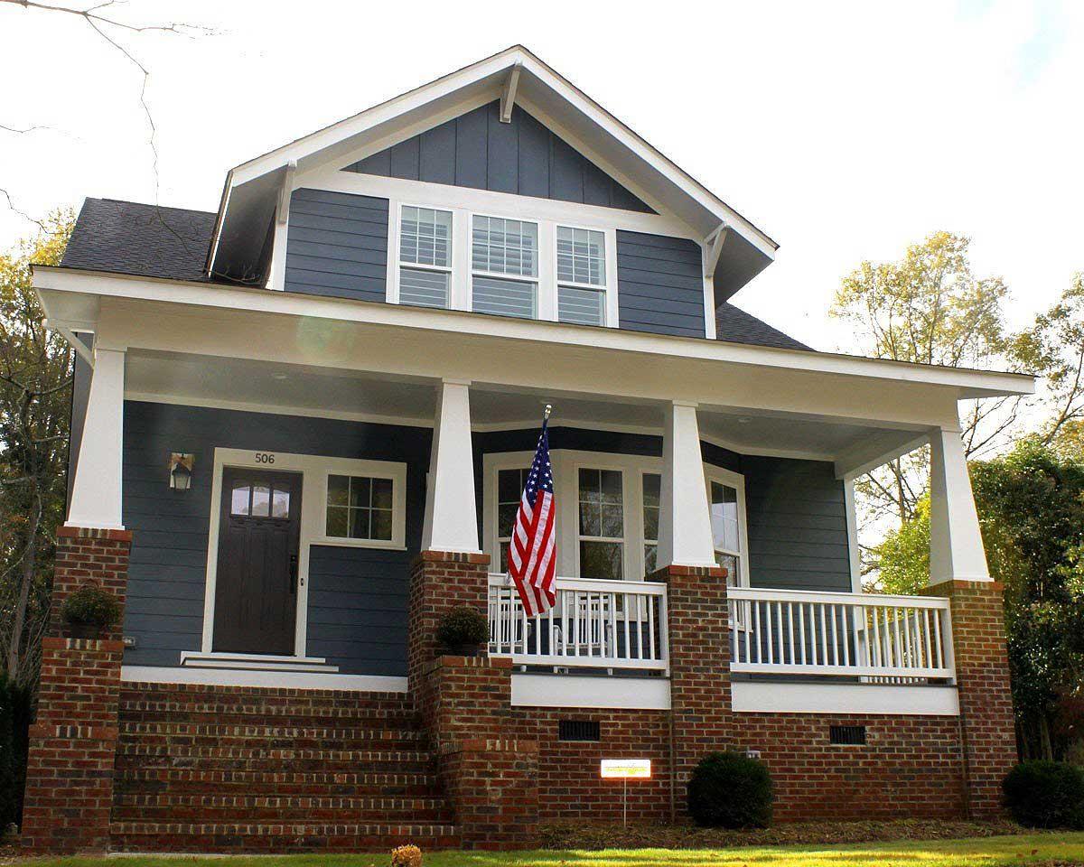 Craftsman-style house plan exterior with a front porch, gabled roof, and brick foundation. Features a second-story dormer and white trim.