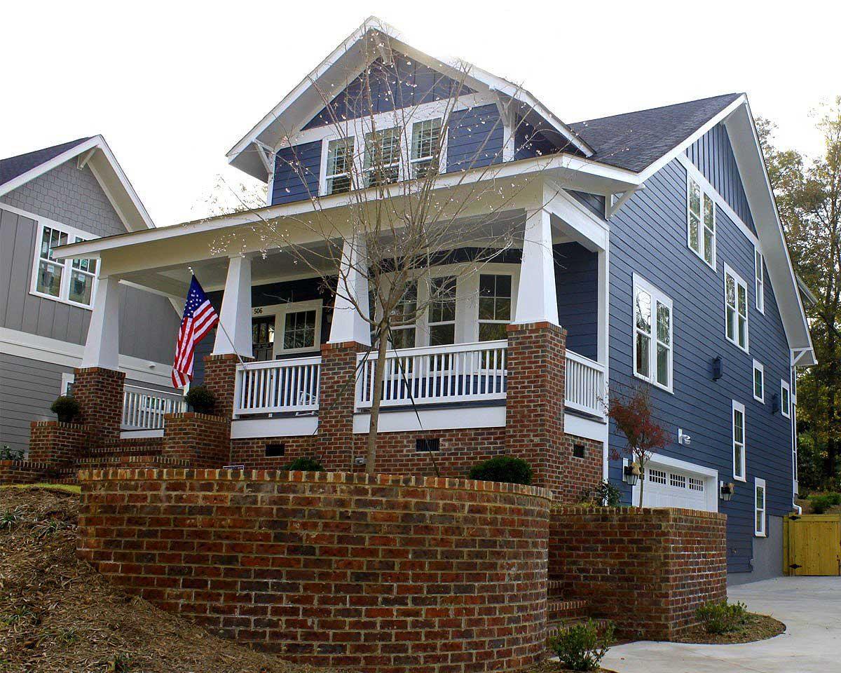Craftsman house plan exterior with a deep front porch, brick retaining walls, and a side-facing garage.
