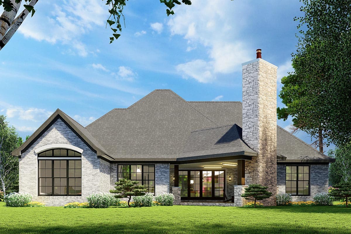 House plan exterior: Single-story, grey brick, prominent stone chimney, covered porch with double doors, arched window.