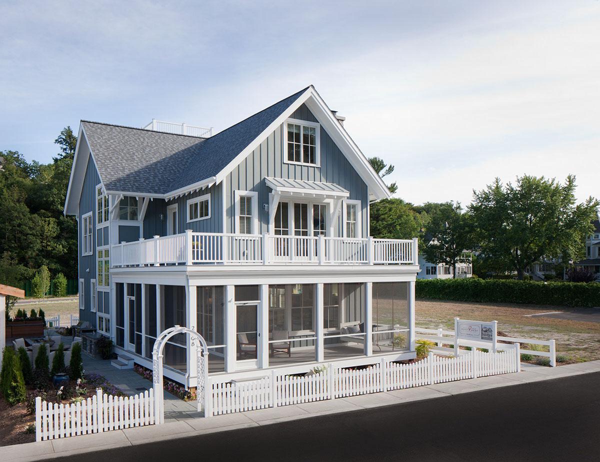 House plan exterior: Two-story Modern Farmhouse with gabled roof, screened-in porch, second-story balcony, and white picket fence.