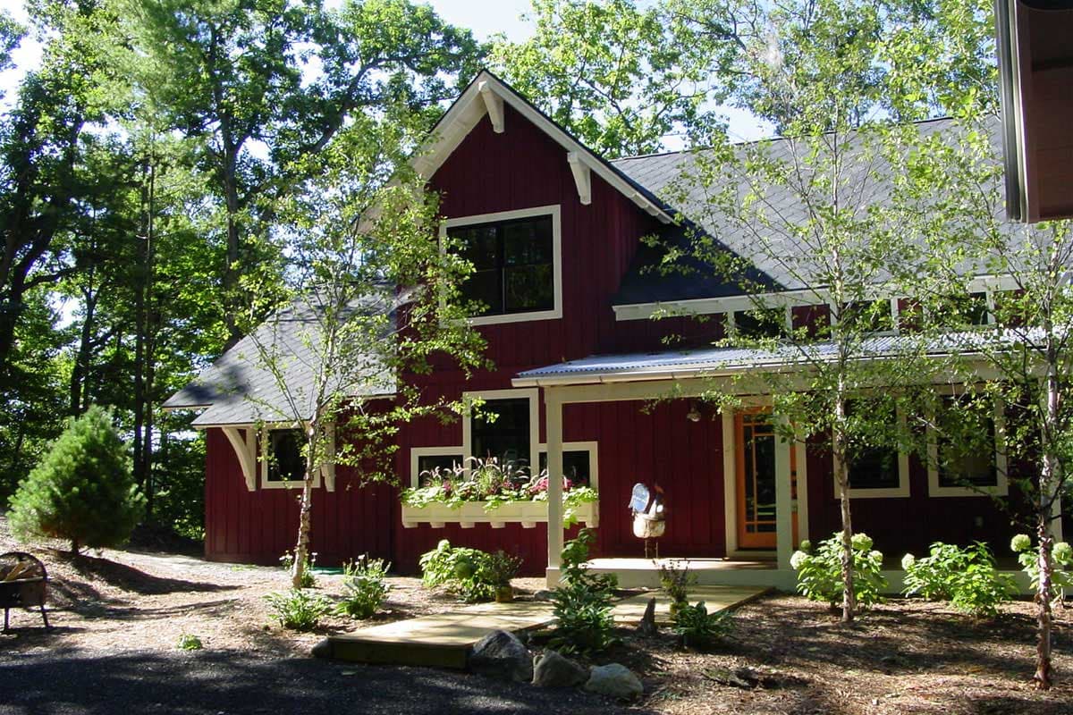 House plan exterior: Two-story modern barn style with a gabled roof, prominent white trim, and a covered front porch.