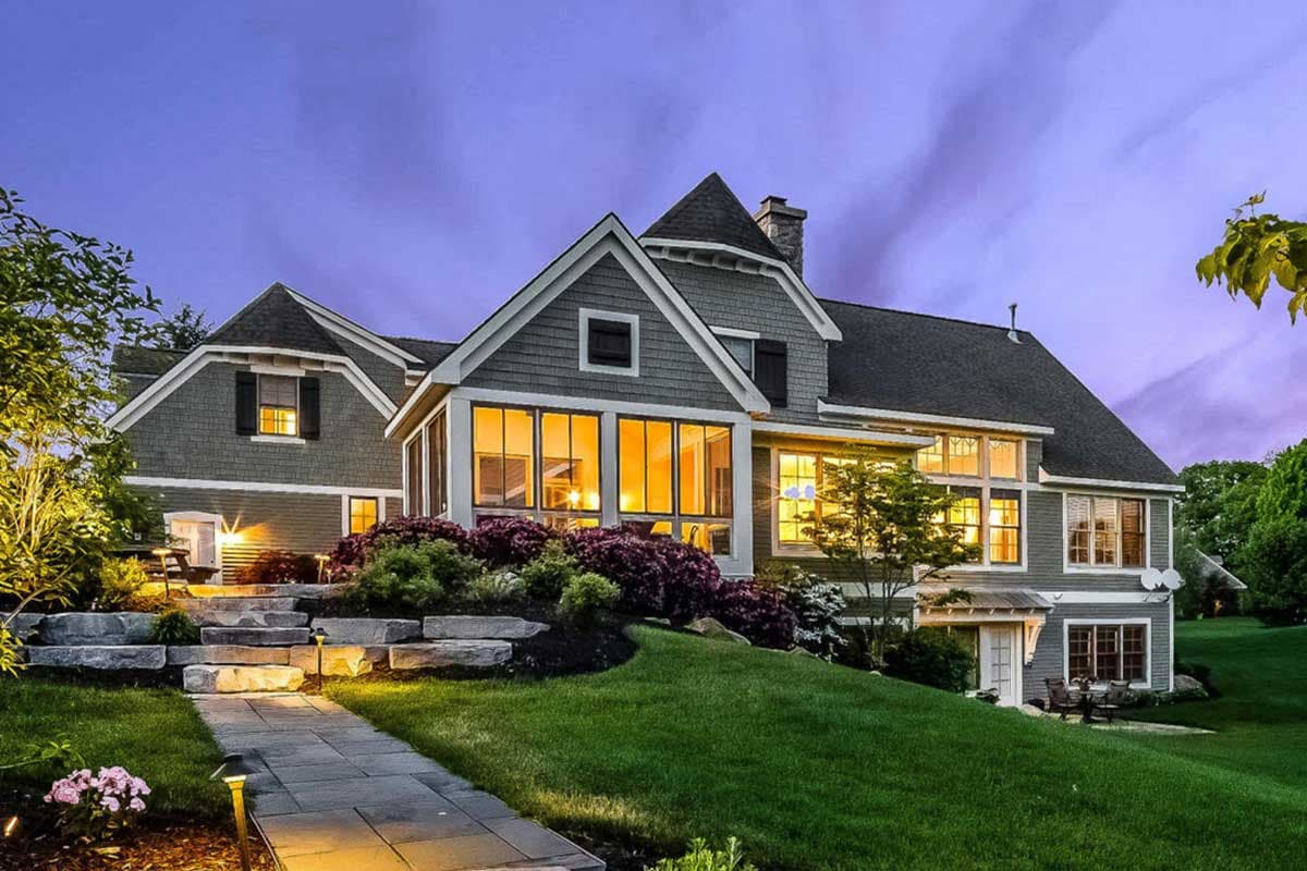House plan exterior, two-story gray shingle-style home with prominent gables, dormers, and large windows.