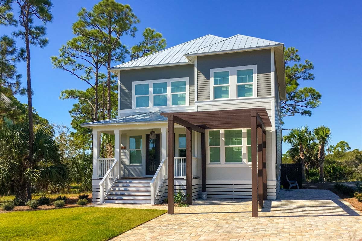 Two-story house plan exterior with metal roof, covered front porch with stairs, and wooden pergola over patio.