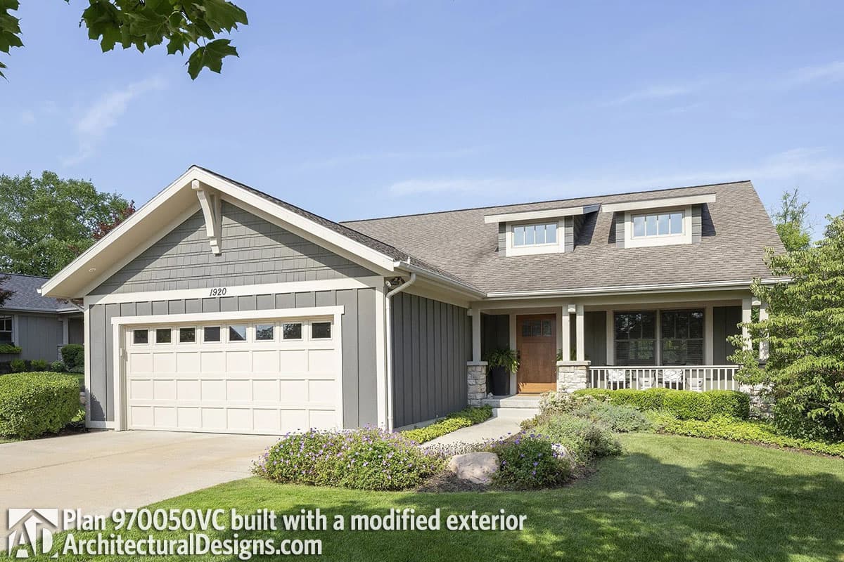 House plan exterior with Craftsman-style gables, dormers, a covered porch, and a side-entry garage.