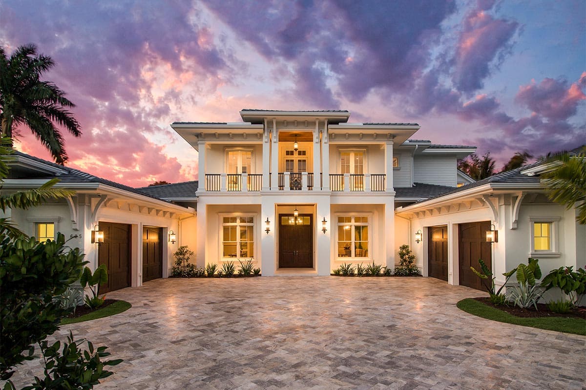 House plan exterior featuring a two-story design. Key features include a balcony, garage, and a symmetrical facade with a double-door entry.