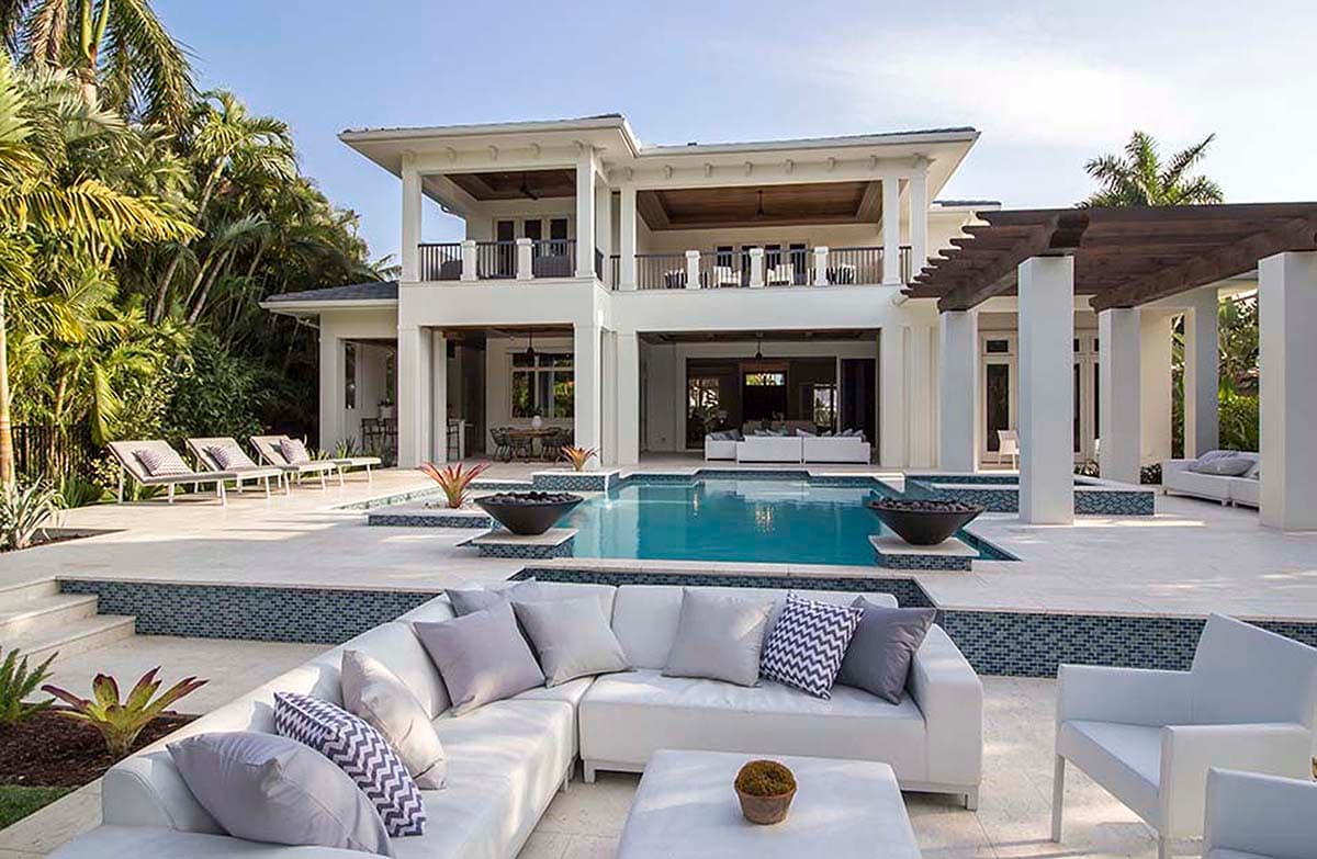 Modern two-story house plan exterior with wraparound balconies, covered patio, and L-shaped swimming pool.