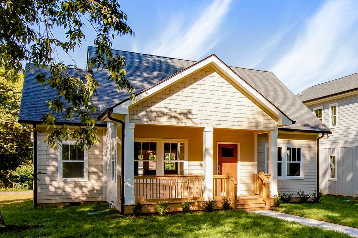 House plan exterior. Craftsman style, one story home with front porch supported by columns. Features include gabled roof and shingle siding.