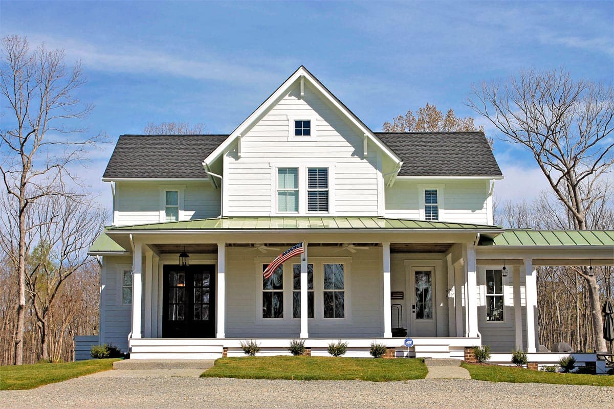 Modern Farmhouse two-story house plan exterior with a wraparound porch, gables, and a metal roof.