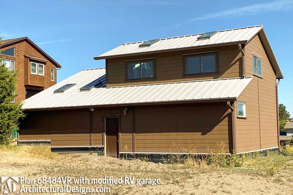 House plan exterior: Modern style, two stories, brown siding, metal roof with skylights, modified RV garage.