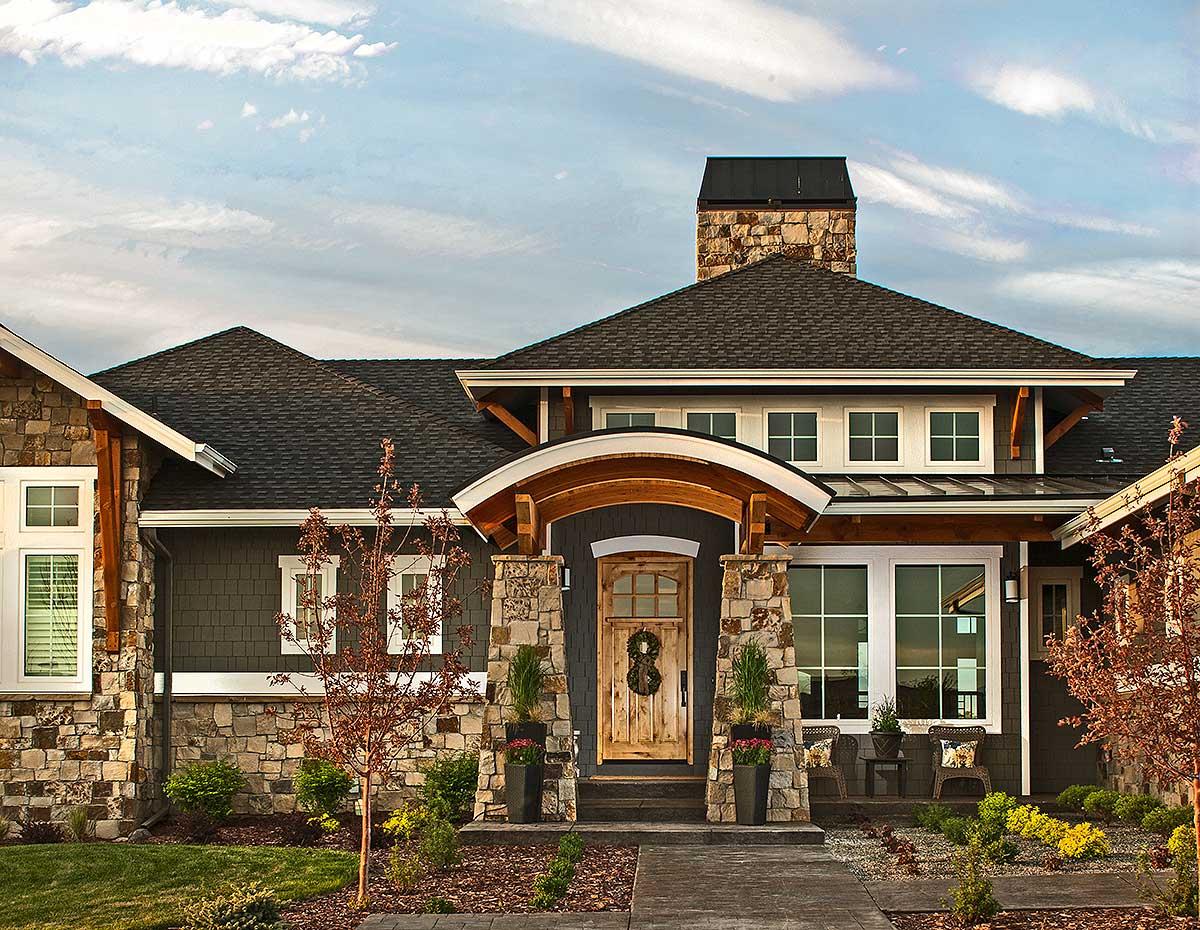 Craftsman style house plan exterior with stone and wood accents, covered entryway with arched beam detail, and multiple gables.