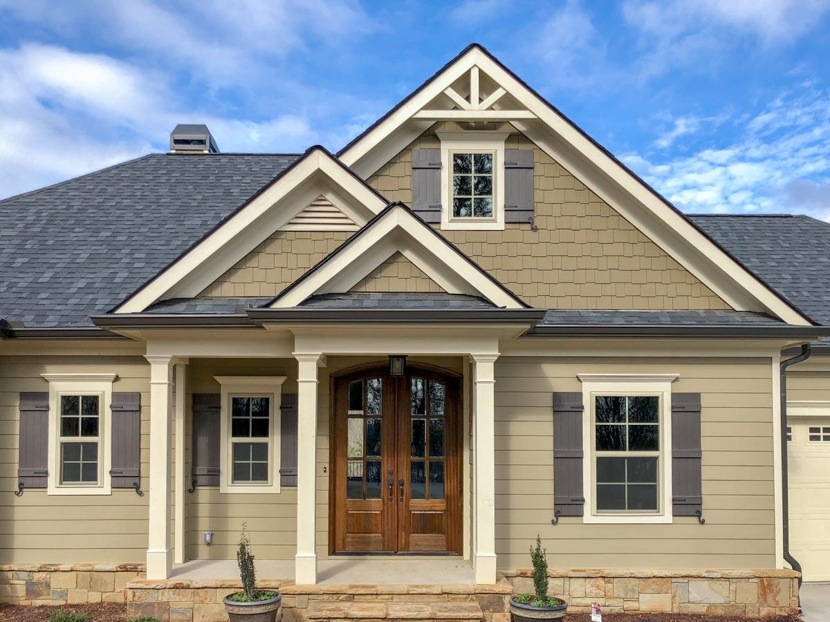 House plan exterior: Craftsman style, two stories, double front doors, gables with decorative trim, and dormer window.