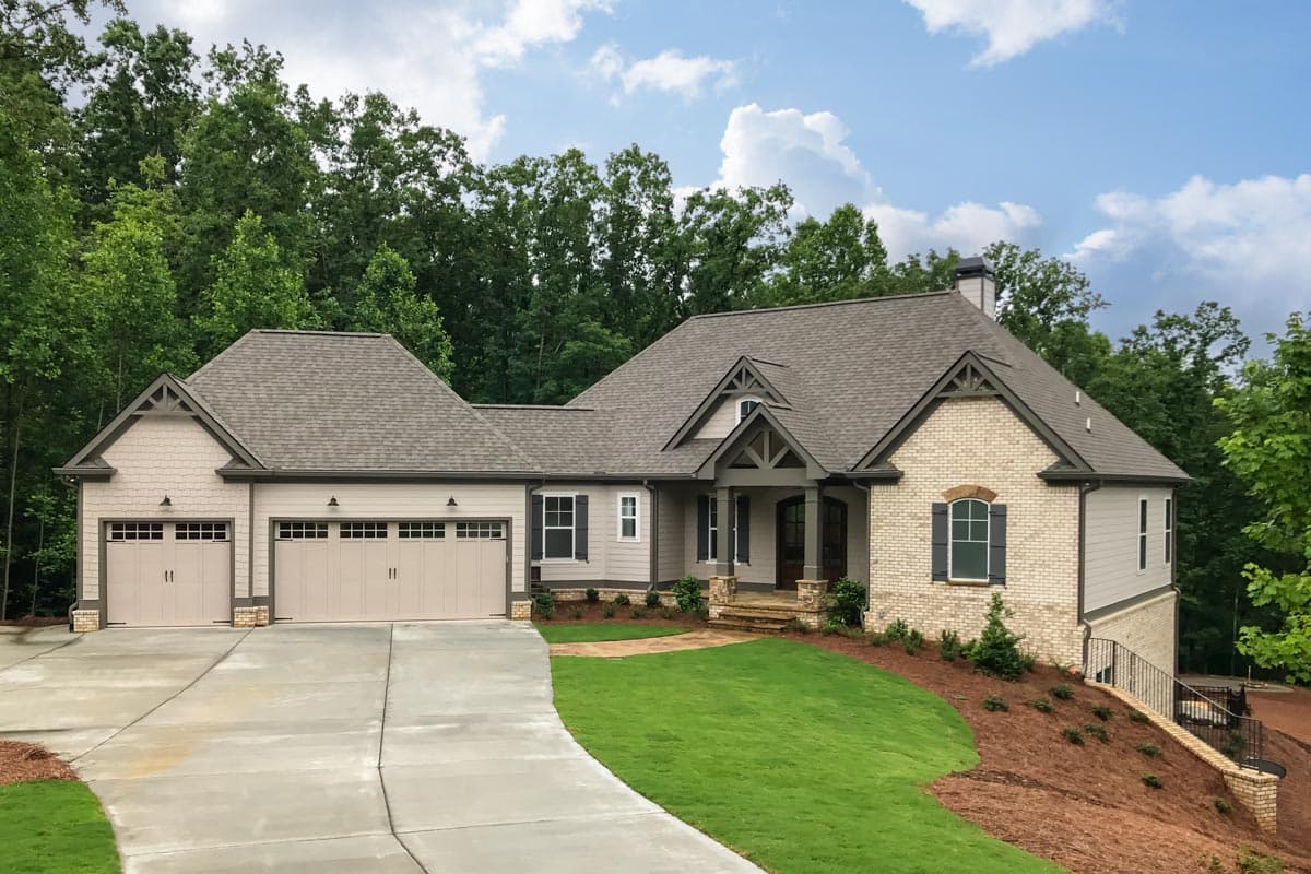 House plan exterior with Craftsman details. Features include a front-entry porch, multiple gables, and a three-car garage. Two-story structure.