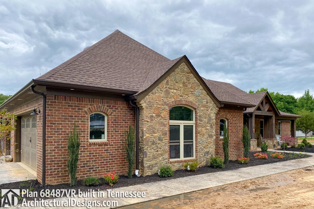 House plan exterior with brick and stone facade, attached garage, and prominent gabled entry.