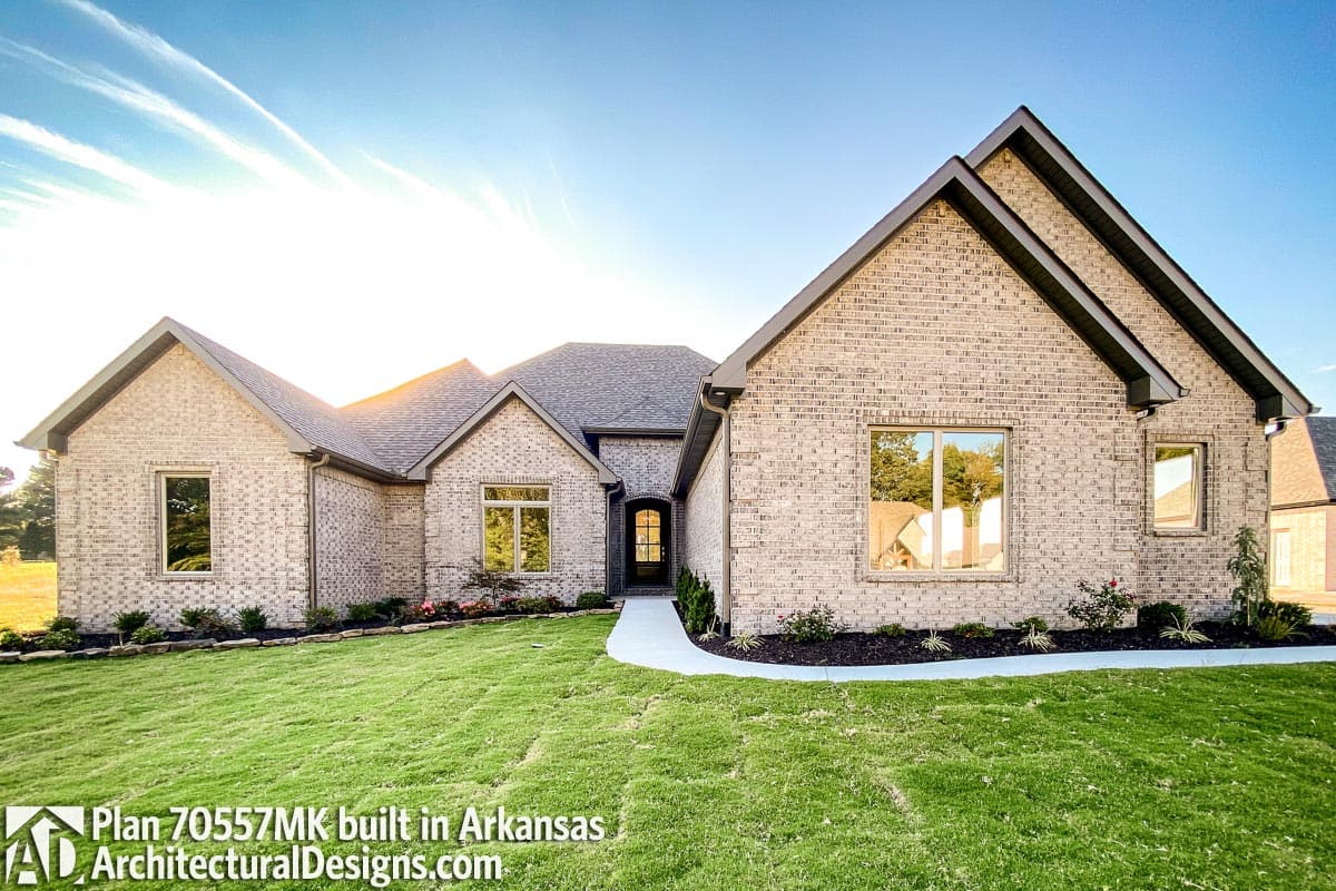 House plan exterior of a one-story home with brick facade, gabled rooflines, and arched entry.