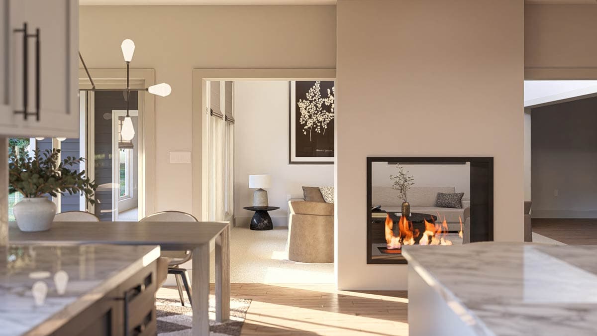 Interior rendering showing a fireplace dividing a kitchen and living area with natural light. Modern lighting fixtures and cabinetry visible.