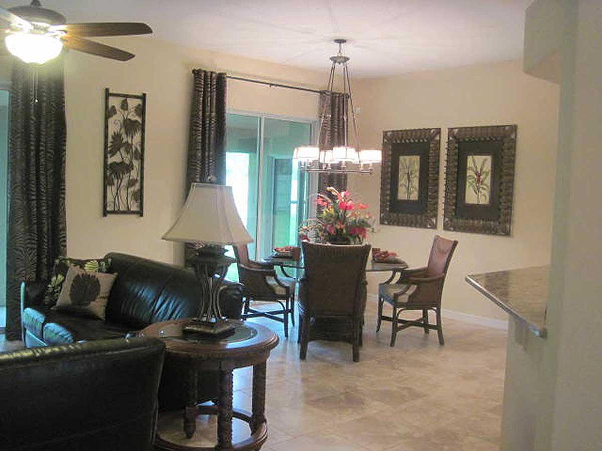 Living and dining area with leather sofa, dining set with chairs, and decorative wall art.