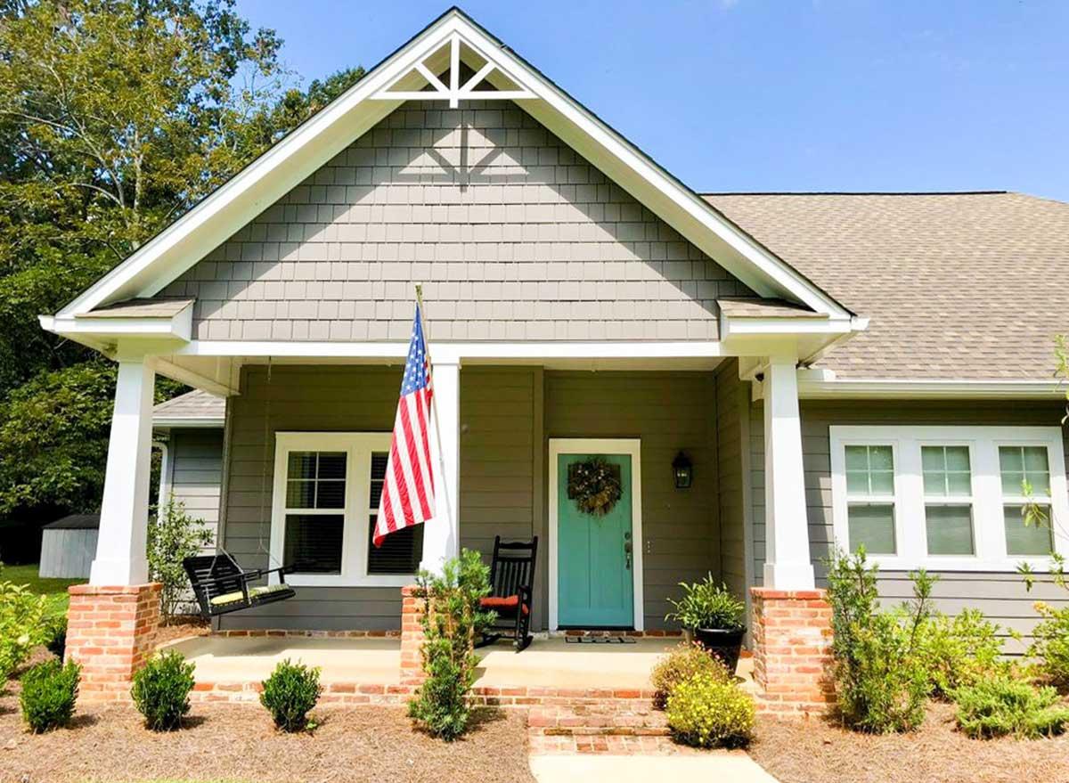 House plan exterior: One-story Craftsman style with a covered front porch, shingle siding, and decorative gable trim.