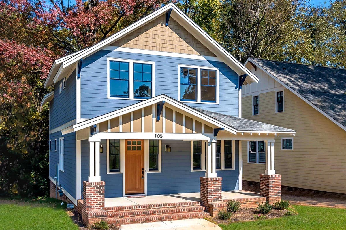 House plan exterior. Two-story Craftsman home with a front porch supported by brick columns, gables, and a prominent roofline.