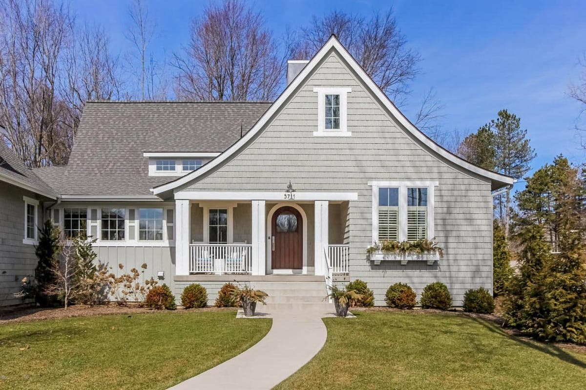 House plan exterior: Craftsman style, two stories, covered front porch, gable dormer, and wood shake siding.