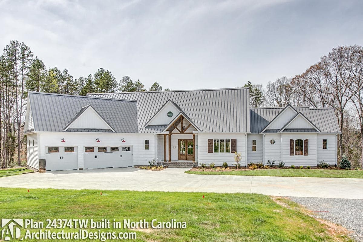 House plan exterior: Modern Farmhouse style, one story, with metal roof, side-entry three-car garage, and covered entry.