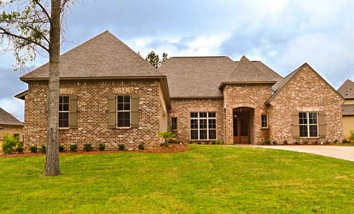 House plan exterior with brick facade, multiple gables, and a prominent front entry. Features include a side-entry garage and brick shutters.