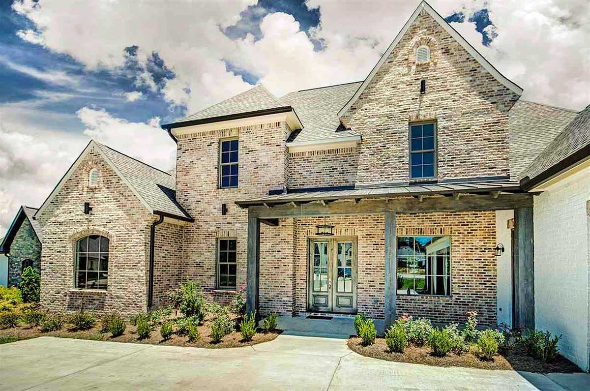 House plan exterior of a two-story brick home with a covered porch, gables, and arched windows.