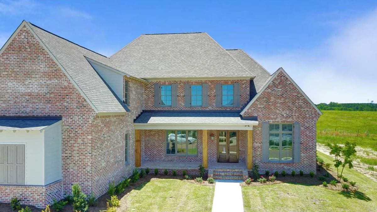 House plan exterior with brick facade, gabled rooflines, and a covered front porch with wooden columns.