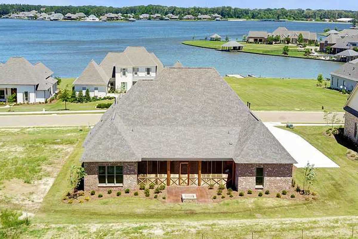 House plan exterior: One-story brick home with a prominent screened-in porch and multiple gables.