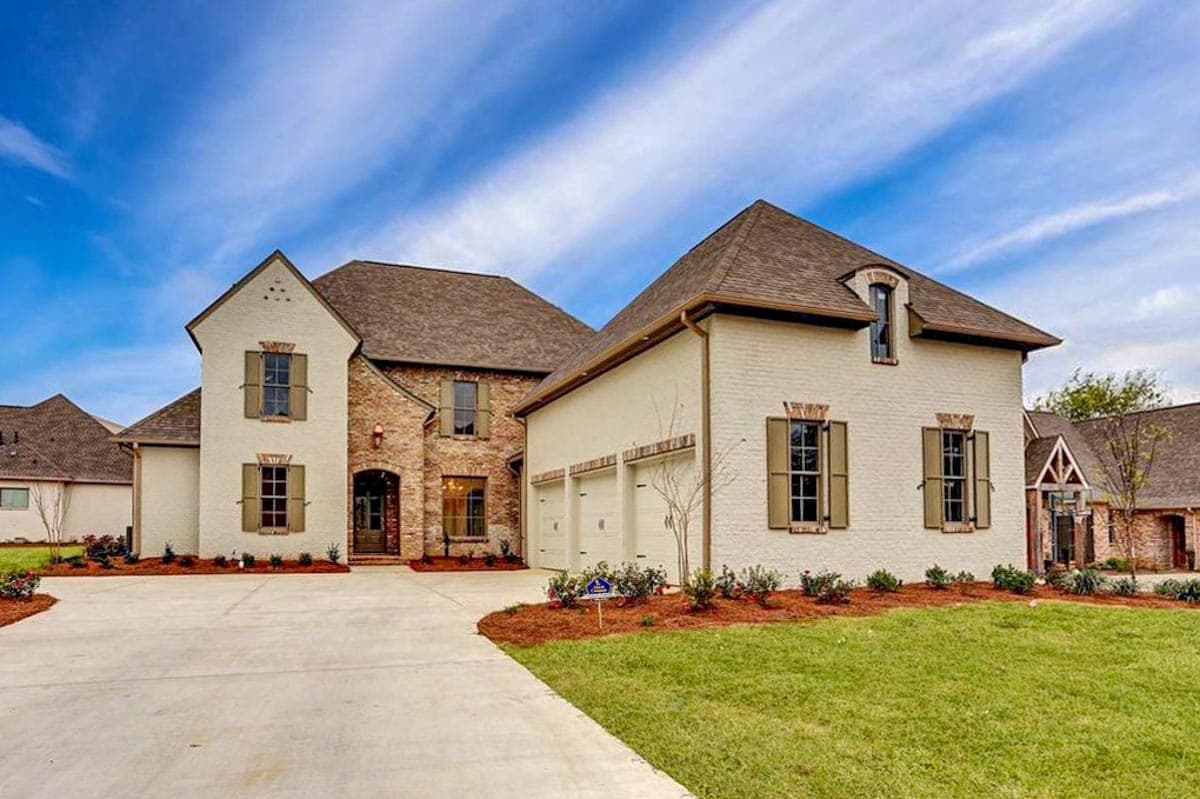 House plan exterior featuring a two-story design with brick and painted brick facade, multiple gables, and attached three-car garage.