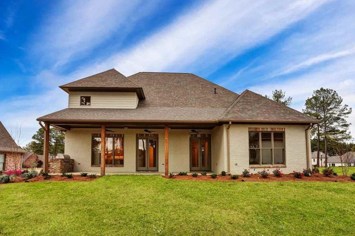 House plan exterior: Two-story traditional home with covered rear porch, multiple gables, and brick accents.
