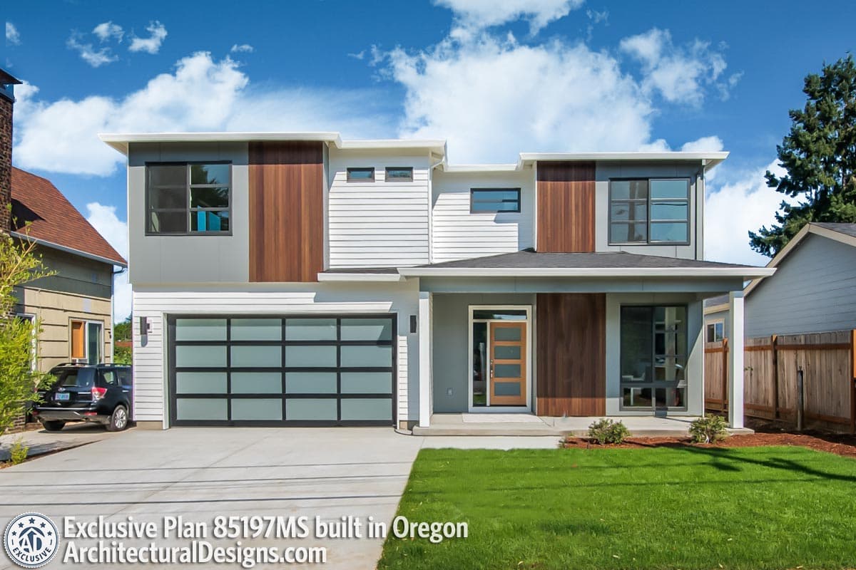 Modern two-story house plan exterior with a glass garage door, wood paneling, multiple gables, and a covered entry.