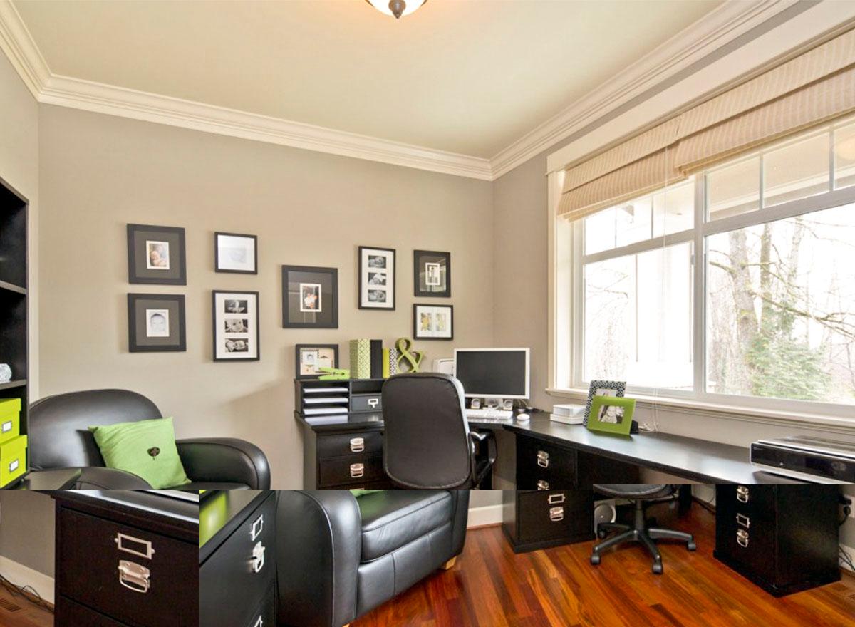 Home office with dark wood desk, black leather chair, large window, and framed photos on the wall.