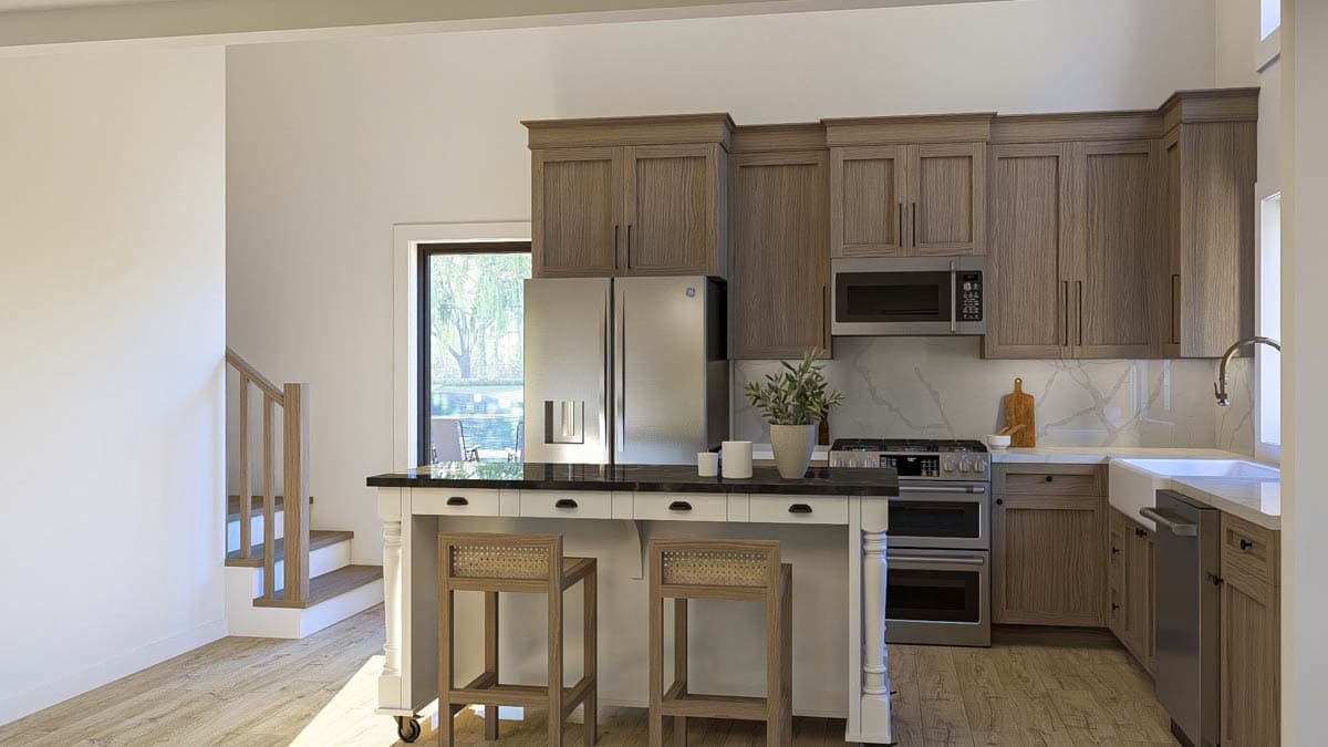 Kitchen featuring wood cabinetry, stainless steel appliances, island with seating, and a staircase nearby.