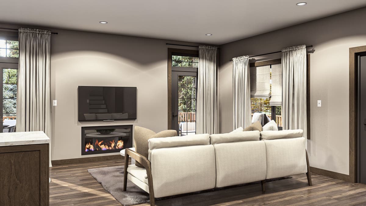 Living room with fireplace, mounted television, sofa, and large windows with outdoor views.