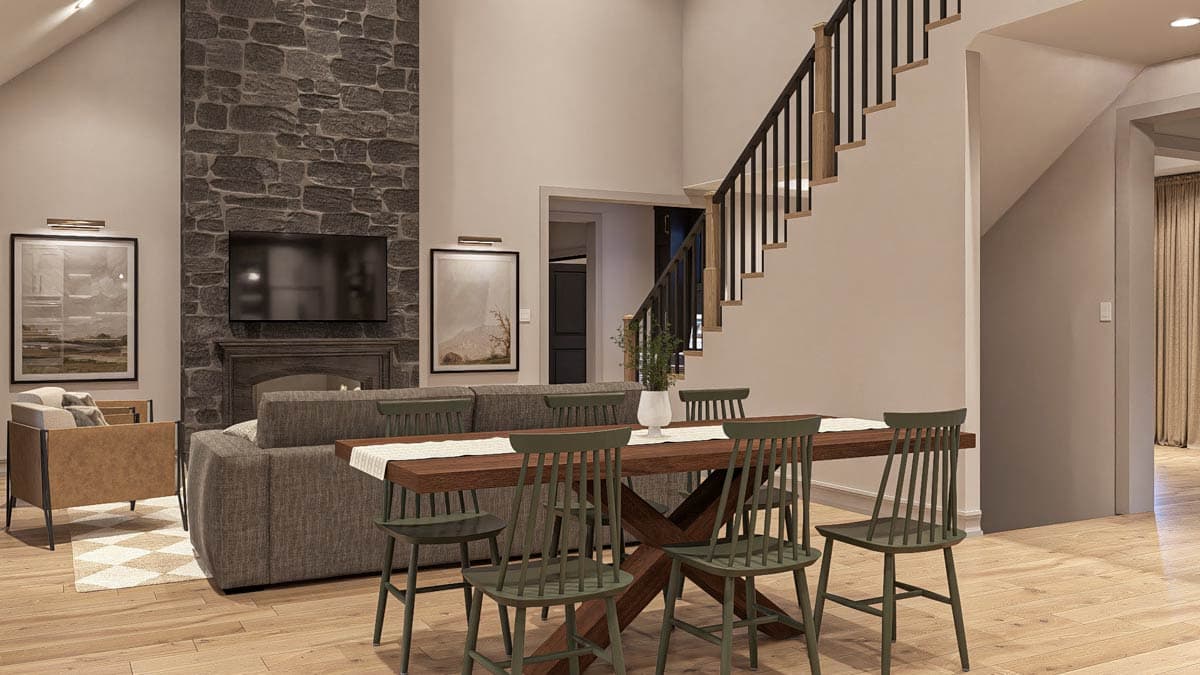 Open-concept living space with stone fireplace, dining table, and staircase with black railings.
