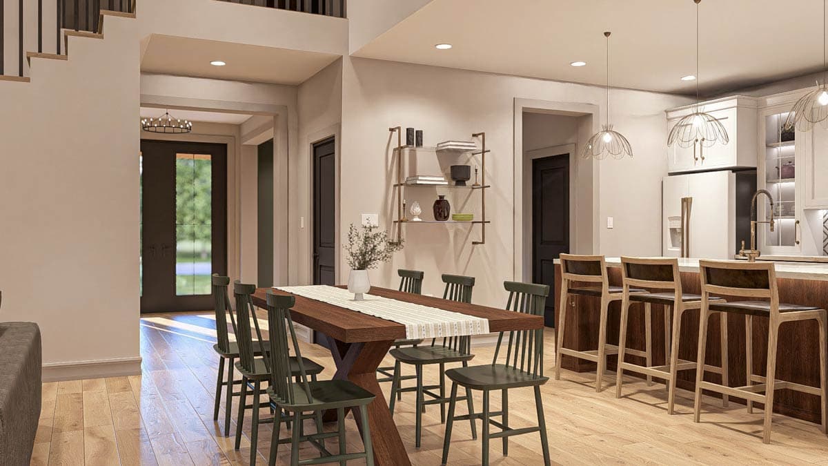 Open-concept dining and kitchen area with a large dining table, island with bar stools, and natural light.